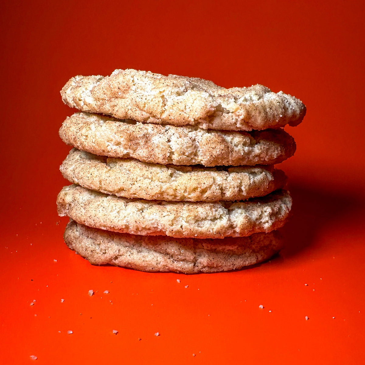 Snarky Snickerdoodle cookies stacked and torn in half, showing the inside