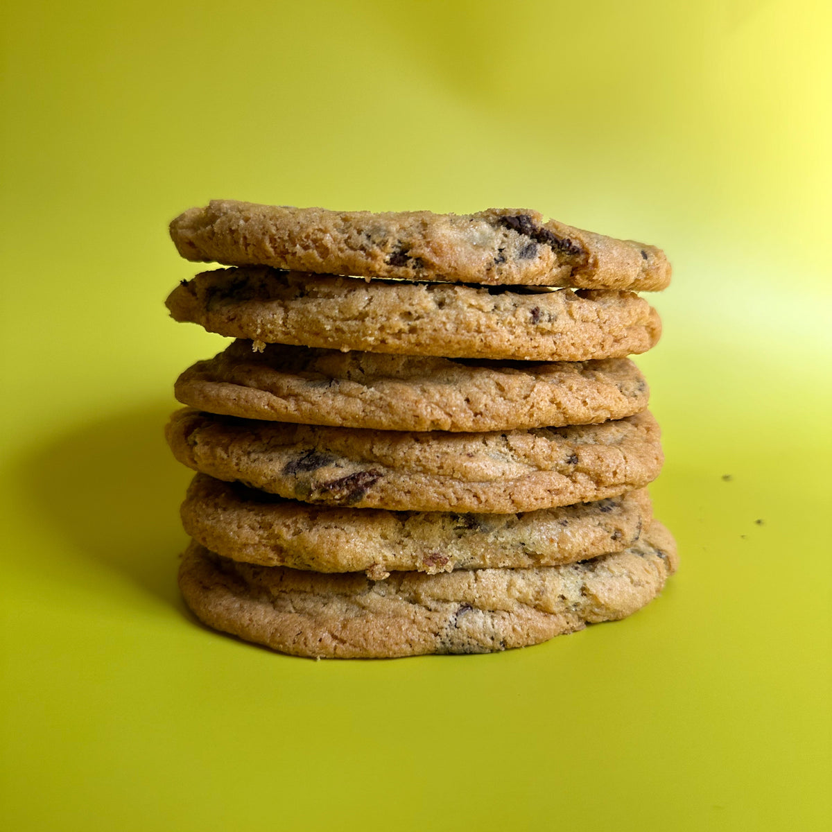 Chocolate Fuckin' Chip cookies stacked and torn in half, showing the inside
